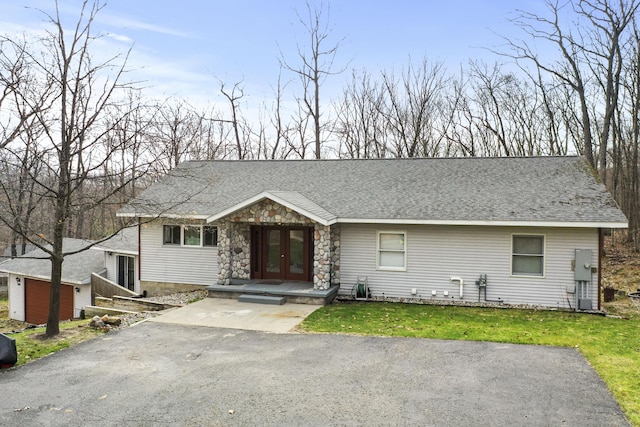 207 Cindy Ave, Roscommon, MI 48653 - view of front of home featuring french doors, stone siding, a shingled roof, and a front yard