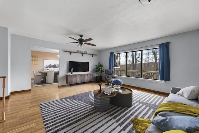 207 Cindy Ave, Roscommon, MI 48653 - living room featuring wood finished floors, a ceiling fan, and baseboards