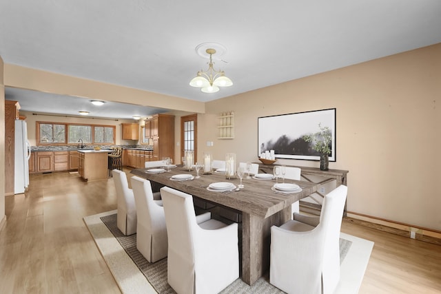 207 Cindy Ave, Roscommon, MI 48653 - dining area with light wood-style floors, a chandelier, and baseboards