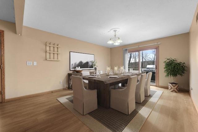 207 Cindy Ave, Roscommon, MI 48653 - dining area with light wood finished floors, a chandelier, and baseboards