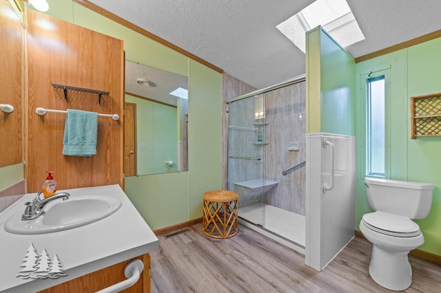 5335 Pinecrest Dr, Lewiston, MI 49756 - full bathroom with a textured ceiling, a skylight, crown molding, a stall shower, and wood finished floors