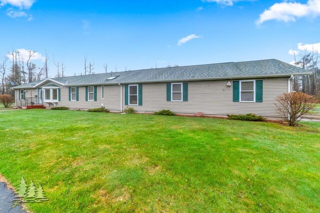 5335 Pinecrest Dr, Lewiston, MI 49756 - ranch-style house featuring a shingled roof and a front yard