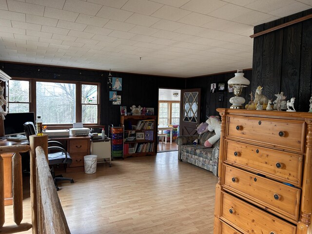 home office with wooden walls and wood finished floors