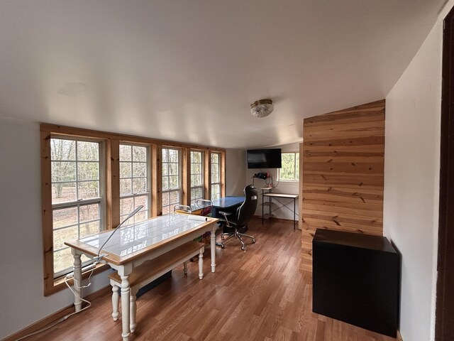 dining room with wooden walls and wood finished floors