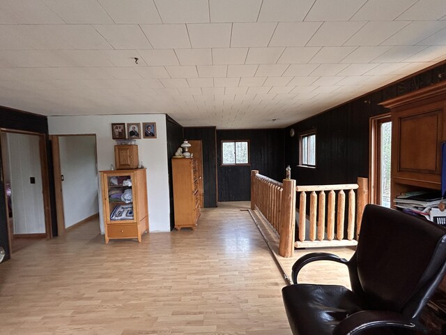 interior space featuring baseboards, wood walls, and light wood-style flooring