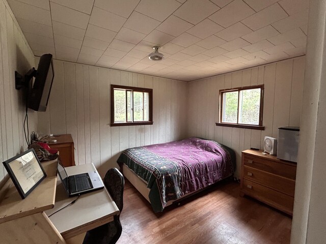 bedroom with wood walls and wood finished floors