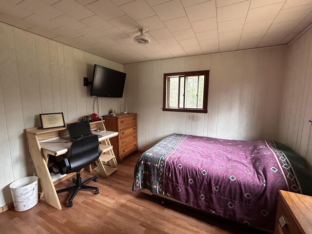 bedroom with wooden walls and wood finished floors