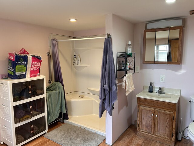 bathroom featuring vanity, recessed lighting, wood finished floors, and toilet