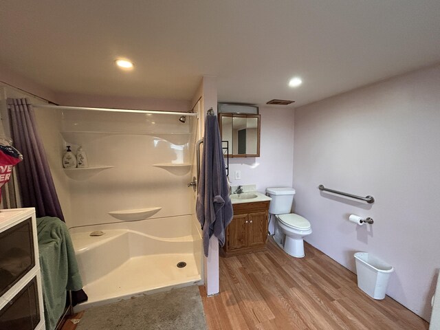 bathroom featuring visible vents, vanity, curtained shower, wood finished floors, and toilet