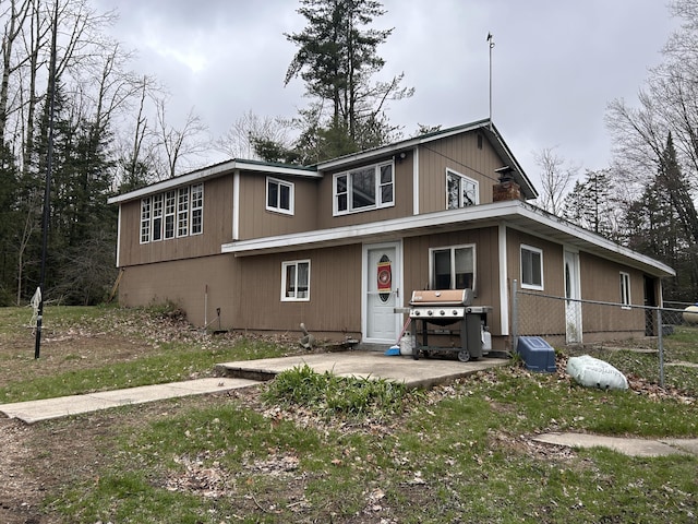 view of front of home with a patio area and fence