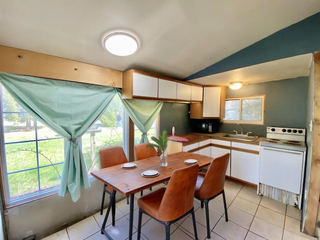 kitchen featuring electric range, white cabinets, a sink, light tile patterned floors, and vaulted ceiling