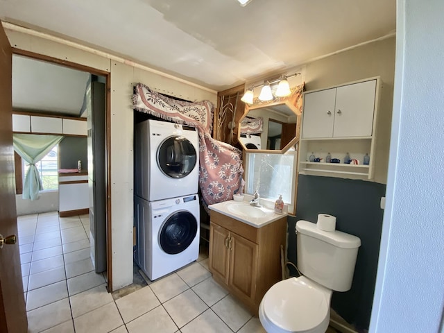 bathroom featuring toilet, tile patterned floors, stacked washer and clothes dryer, and vanity