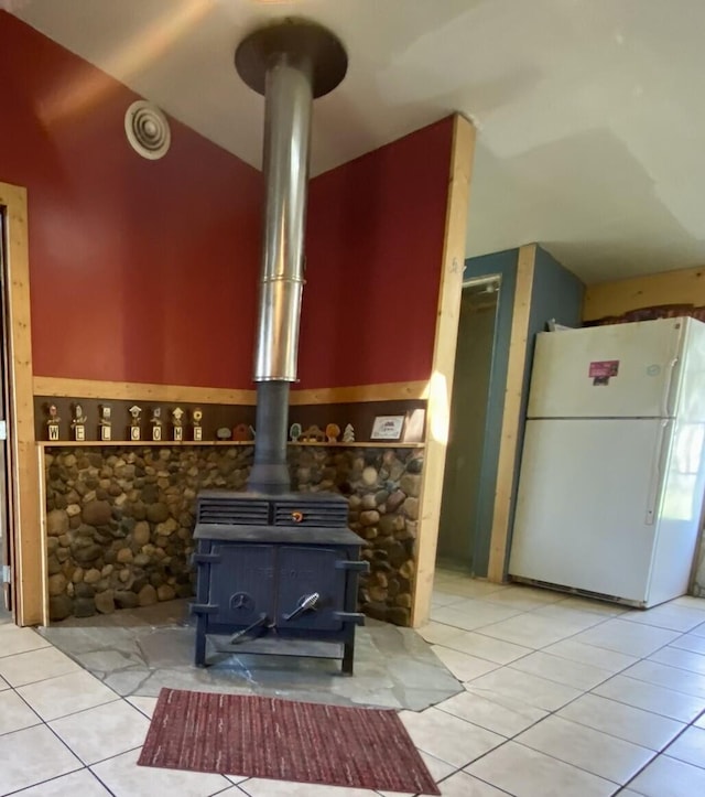 interior details featuring freestanding refrigerator and a wood stove