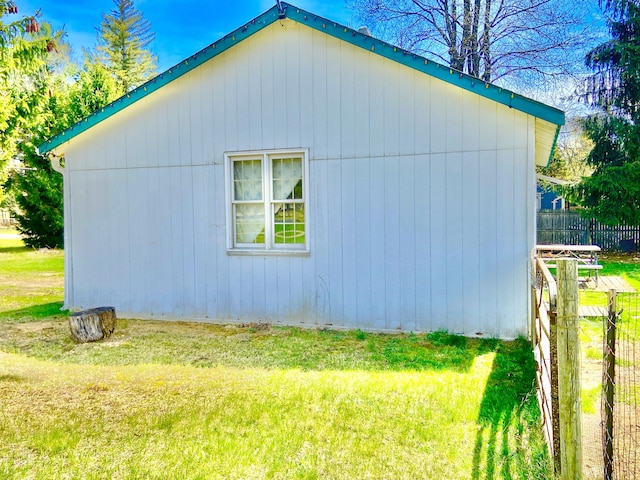 view of side of property featuring fence and a lawn