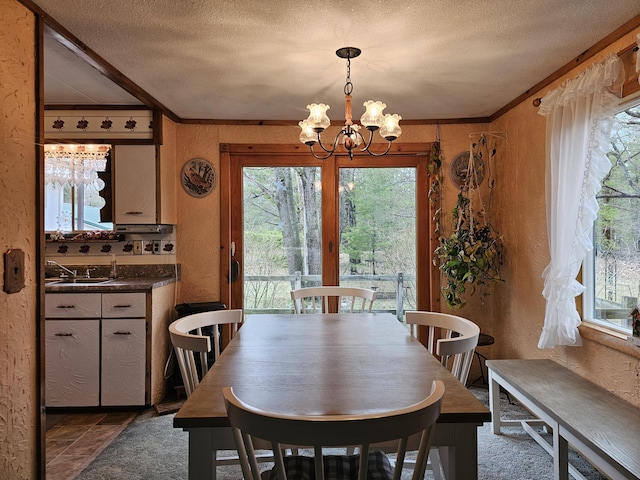 dining space featuring a textured ceiling, a textured wall, and plenty of natural light
