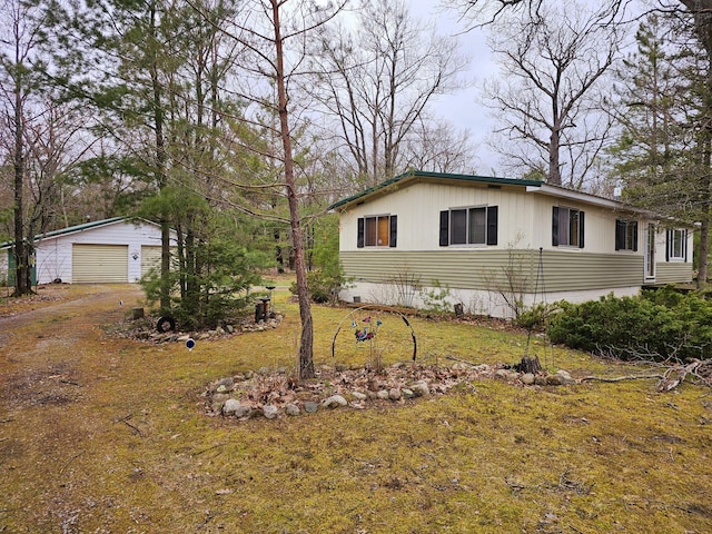 view of front of house featuring an outdoor structure, a garage, and driveway
