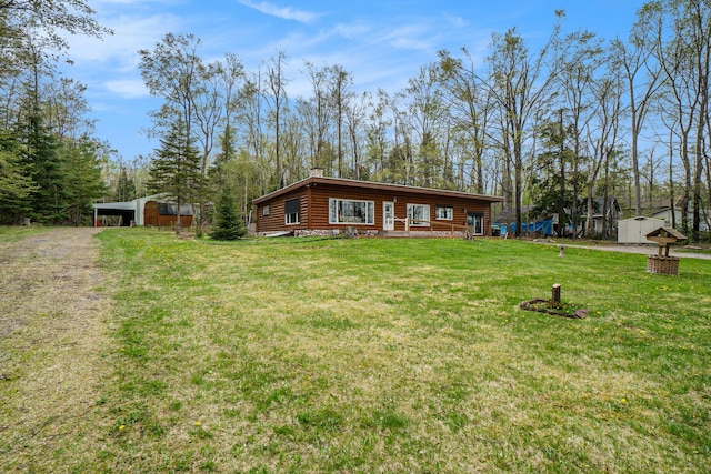 3659 N Straits Hwy, Cheboygan, MI 49721 - view of front of home featuring an outdoor structure, a front yard, a chimney, and faux log siding