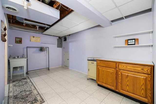 kitchen featuring open shelves, a paneled ceiling, electric panel, visible vents, and light countertops