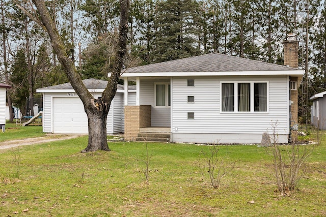 ranch-style house featuring roof with shingles, driveway, a garage, a front yard, and a chimney