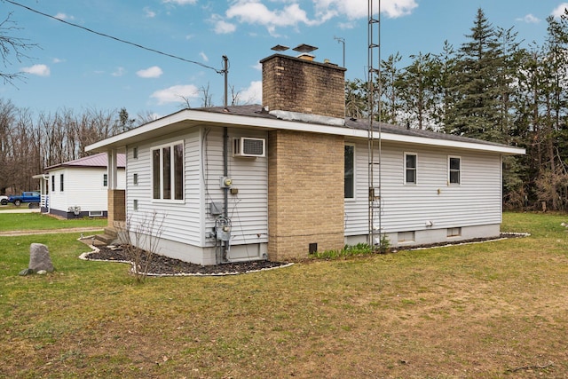 view of home's exterior with a chimney, an AC wall unit, and a lawn
