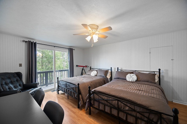 5012 Green Acre Dr, Frederic, MI 49733 - bedroom featuring light wood finished floors, access to exterior, a textured ceiling, and a ceiling fan