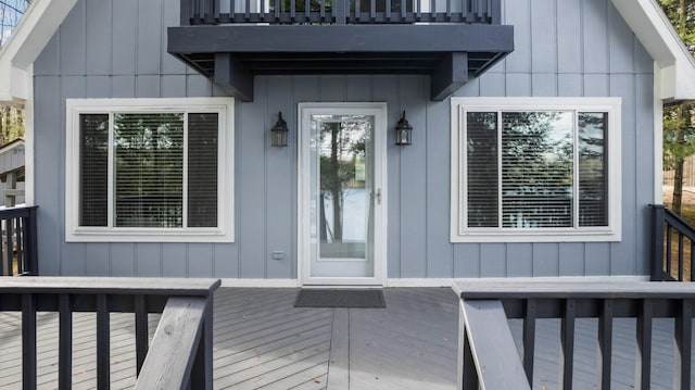 5012 Green Acre Dr, Frederic, MI 49733 - entrance to property with a balcony, a wooden deck, and board and batten siding