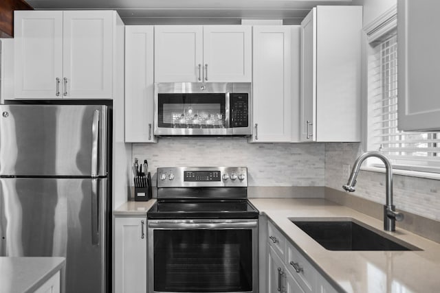 5012 Green Acre Dr, Frederic, MI 49733 - kitchen featuring stainless steel appliances, a sink, tasteful backsplash, white cabinetry, and light stone counters