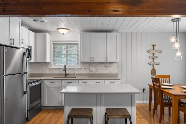 5012 Green Acre Dr, Frederic, MI 49733 - kitchen with stainless steel appliances, a sink, wooden ceiling, light wood finished floors, and tasteful backsplash