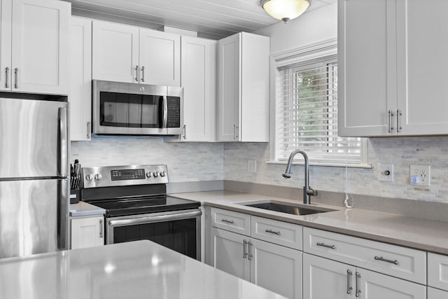 5012 Green Acre Dr, Frederic, MI 49733 - kitchen with appliances with stainless steel finishes, a sink, and white cabinetry