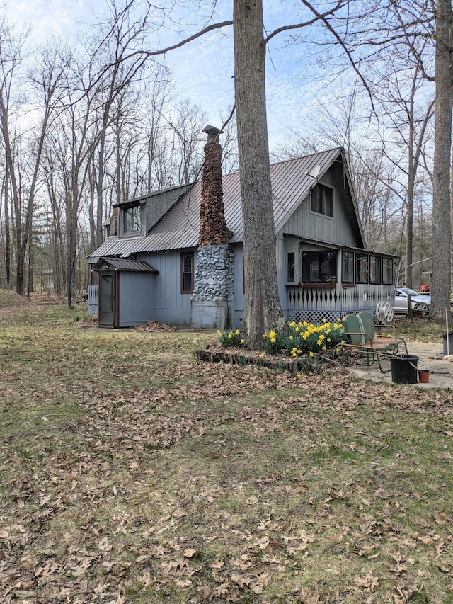view of home's exterior featuring a chimney and metal roof