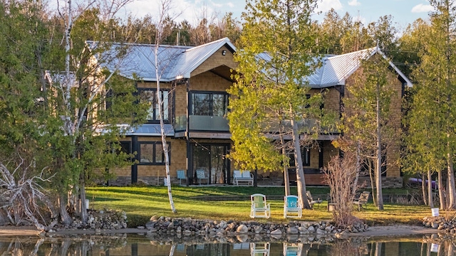 835 M-88, Bellaire, MI 49615 - back of property featuring a lawn, metal roof, and a water view
