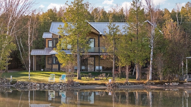 835 M-88, Bellaire, MI 49615 - rear view of house with a standing seam roof, a water view, metal roof, a yard, and stone siding