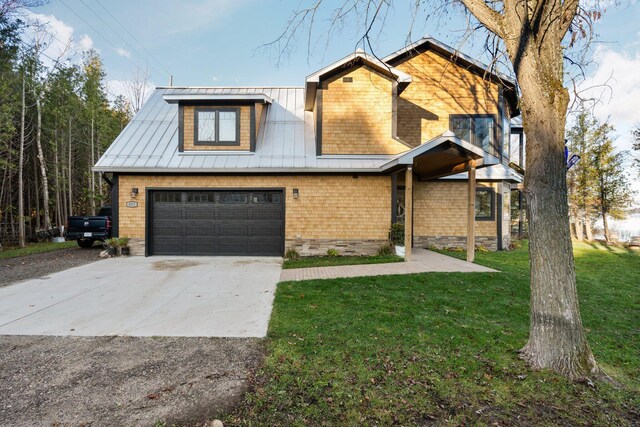 835 M-88, Bellaire, MI 49615 - view of front of property with a front lawn, concrete driveway, metal roof, and an attached garage