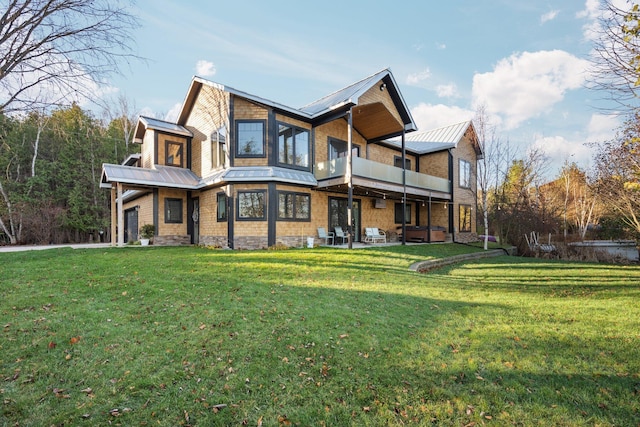 835 M-88, Bellaire, MI 49615 - rear view of property featuring a balcony, metal roof, a lawn, a standing seam roof, and a patio