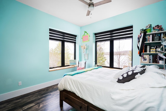835 M-88, Bellaire, MI 49615 - bedroom with multiple windows, baseboards, dark wood-style floors, and a ceiling fan