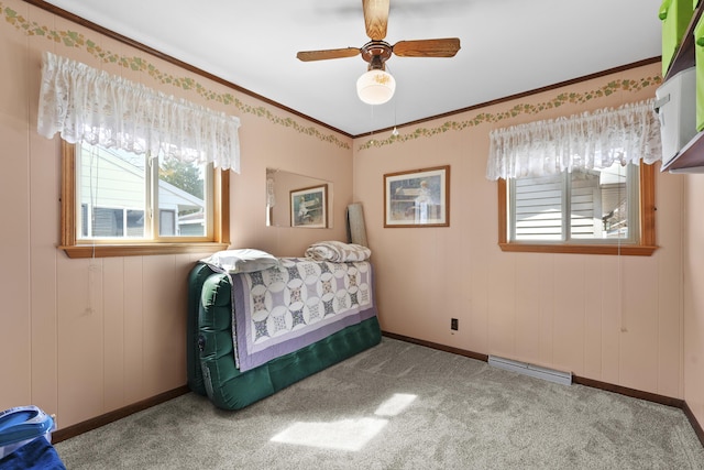 carpeted bedroom with baseboards, ornamental molding, a ceiling fan, and visible vents
