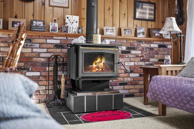 120 Beechwood Ave, Houghton Lake, MI 48629 - details featuring a wood stove, wooden walls, and carpet flooring