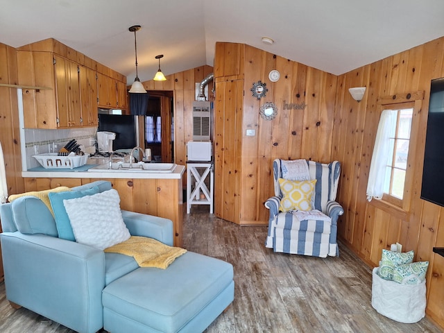 living room featuring wooden walls, vaulted ceiling, and wood finished floors