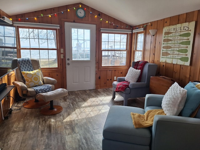 interior space with wooden walls, wood finished floors, and lofted ceiling