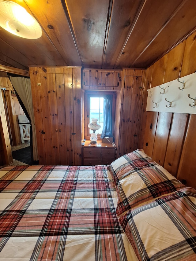bedroom featuring wooden ceiling and wood walls