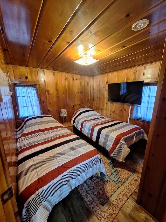 bedroom with wood walls, wood ceiling, and wood finished floors