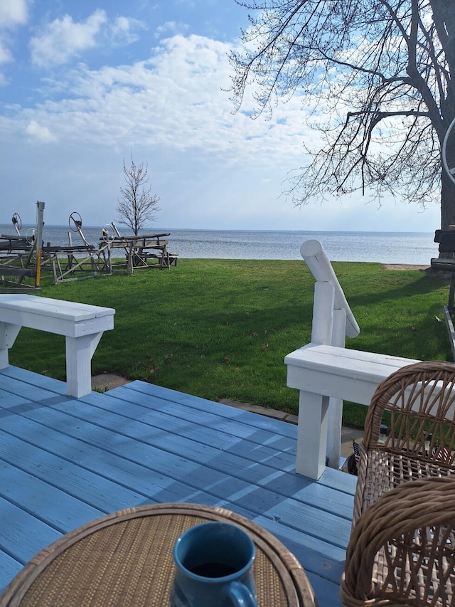 wooden terrace featuring a lawn and a water view