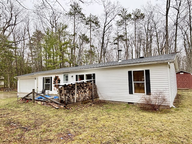 3313 Pleasant View Dr, Lewiston, MI 49756 - rear view of house with a garage, crawl space, a storage unit, a yard, and view of wooded area