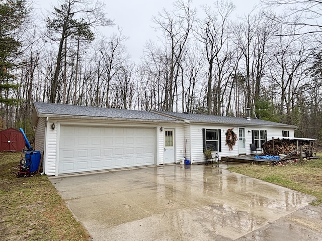 3313 Pleasant View Dr, Lewiston, MI 49756 - view of front of house featuring concrete driveway, an attached garage, a shed, and a wooden deck