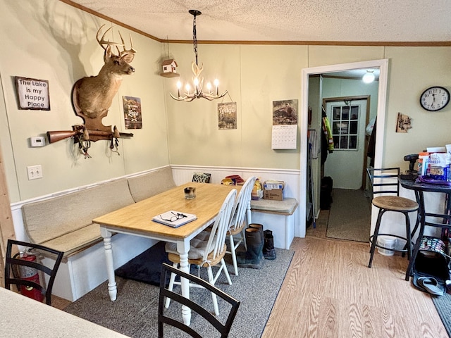 3313 Pleasant View Dr, Lewiston, MI 49756 - dining space with crown molding, a chandelier, a textured ceiling, wood finished floors, and breakfast area