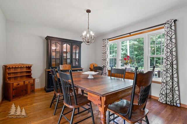 3897 S Mielke Way Rd, Lewiston, MI 49756 - dining area with an inviting chandelier, light wood-style flooring, and baseboards