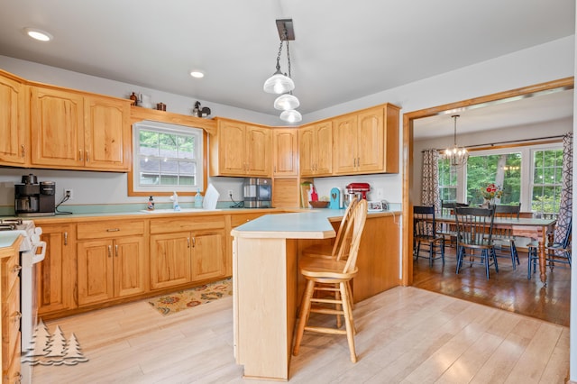3897 S Mielke Way Rd, Lewiston, MI 49756 - kitchen featuring hanging light fixtures, light countertops, a chandelier, stove, and light wood-type flooring