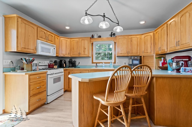 3897 S Mielke Way Rd, Lewiston, MI 49756 - kitchen featuring white appliances, a kitchen breakfast bar, light countertops, light wood-style flooring, and recessed lighting