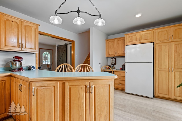 3897 S Mielke Way Rd, Lewiston, MI 49756 - kitchen with freestanding refrigerator, a peninsula, light wood-style floors, a barn door, and light countertops