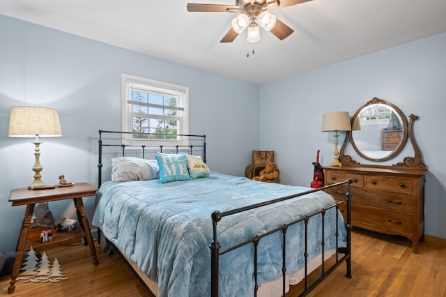 3897 S Mielke Way Rd, Lewiston, MI 49756 - bedroom with baseboards, a ceiling fan, and wood finished floors
